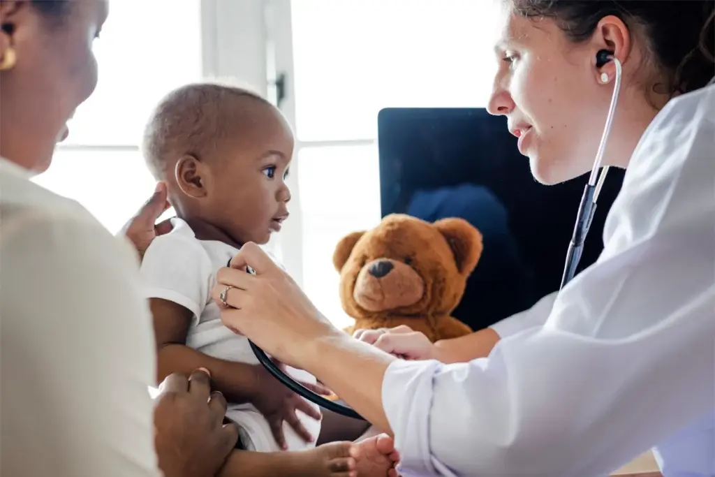 A pediatrician examines a child at a doctor’s office.