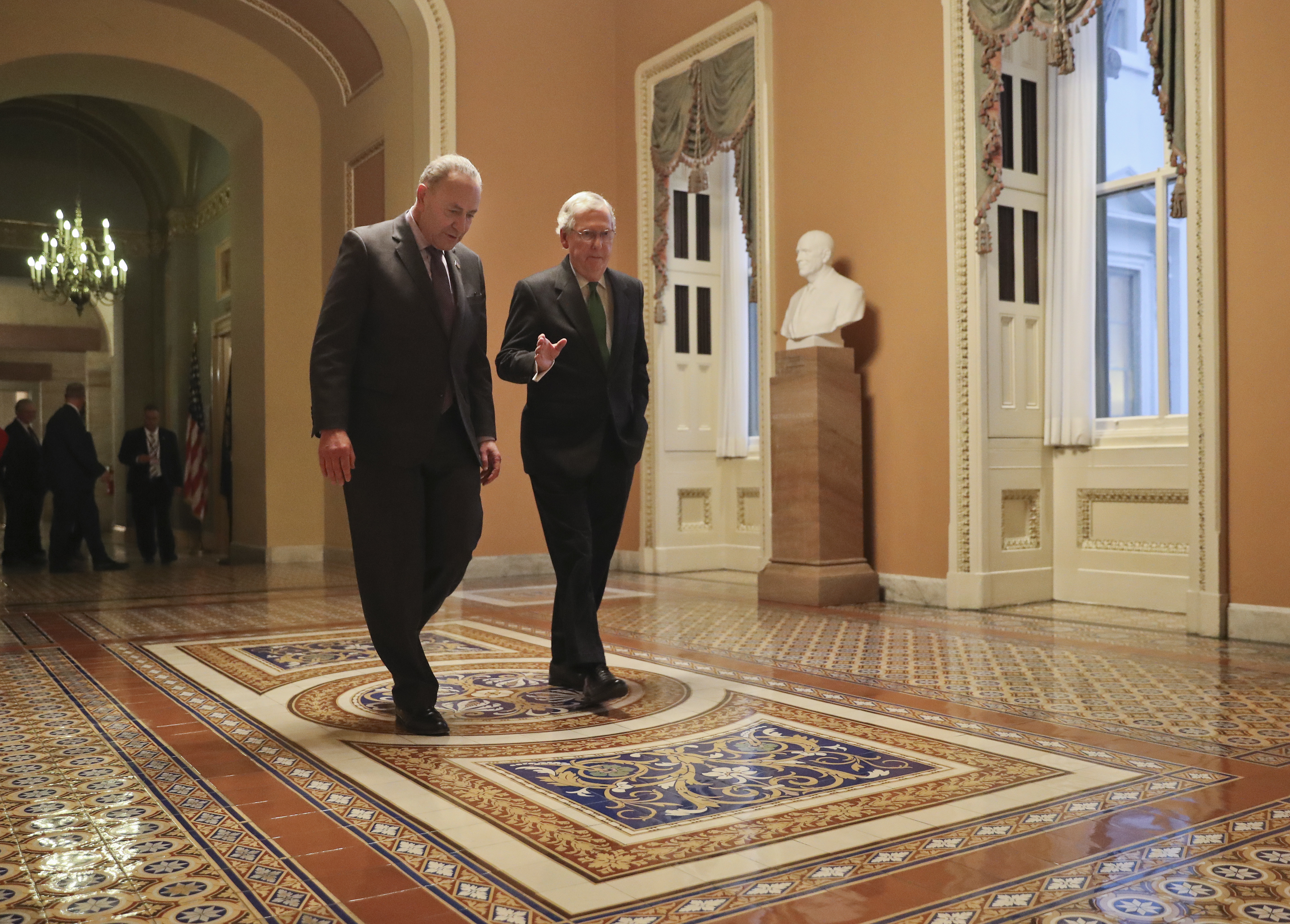 Republican Senate Majority Leader Mitch McConnell (right) and Democrat Senate Minority Leader Chuck Schumer (left) walk to the chamber after collaborating on an agreement in the Senate