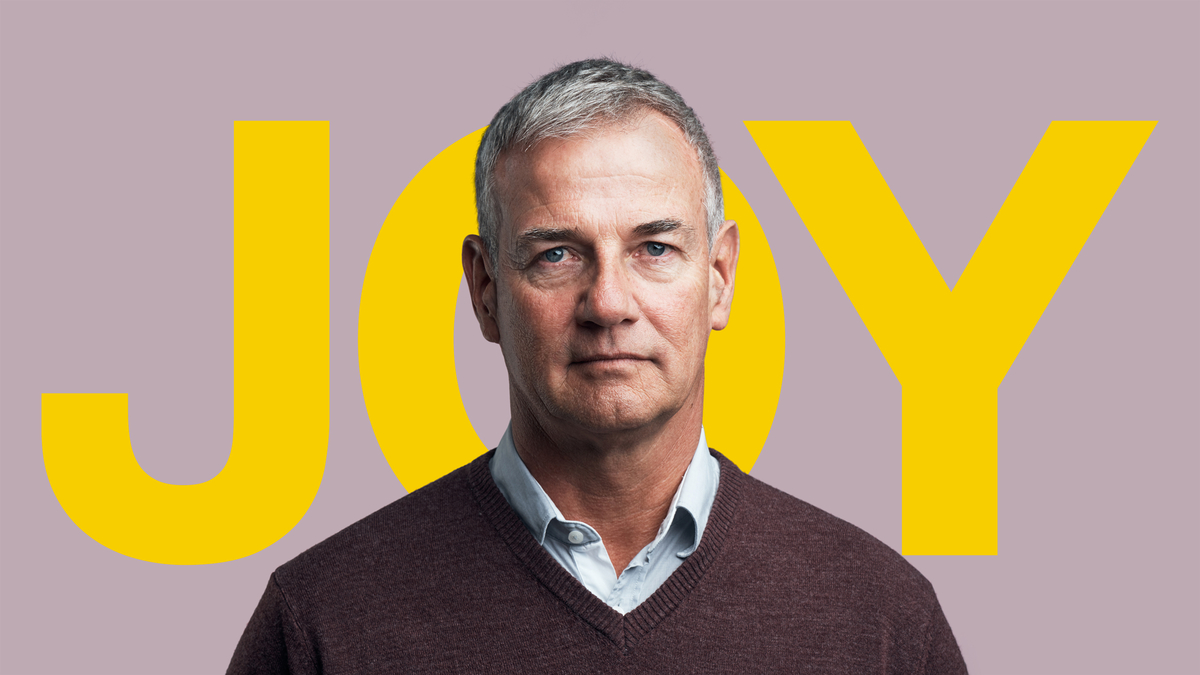 Expressionless man in front of the word JOY