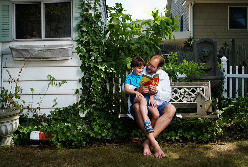 Matt Lerner reading to his son in the backyard of his house.