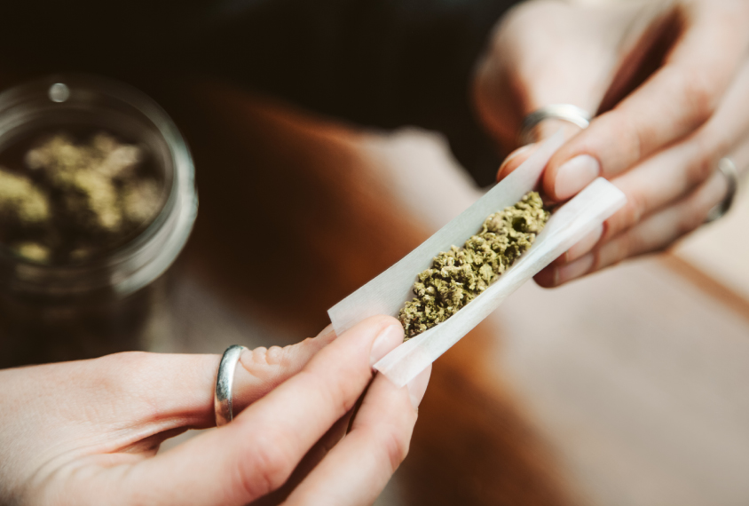Woman rolling a marijuana joint.