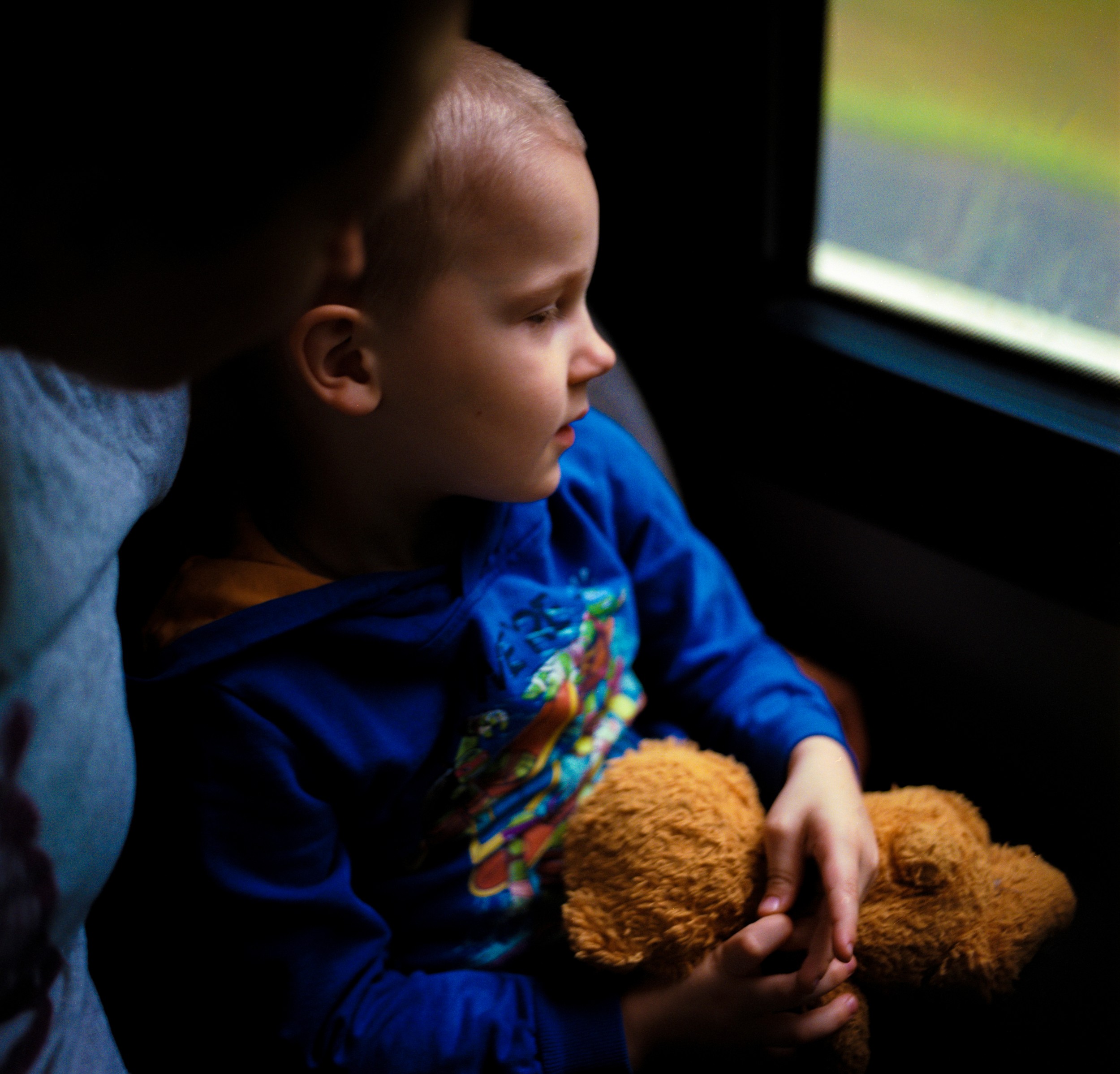 A boy clutches his favorite toy while sitting in his mother’s lap on the camp’s bus. Sometimes parents accompany their children at the camp for autistic children.