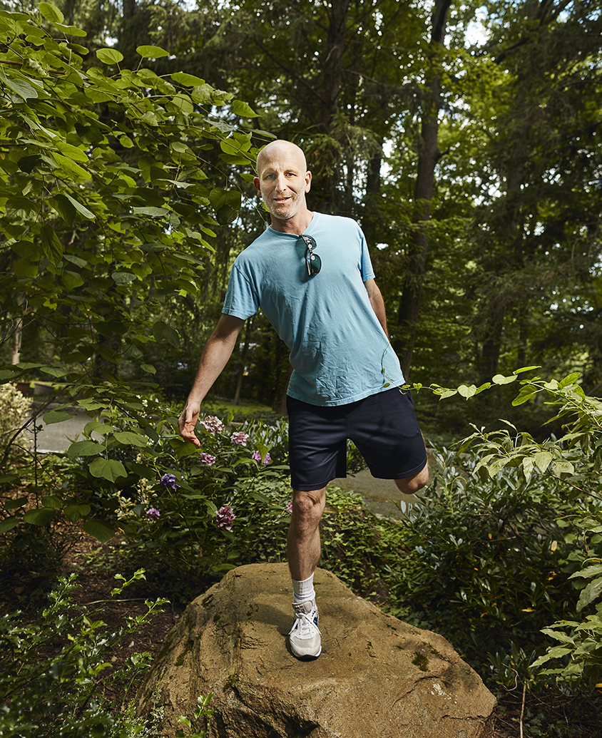 Anthony Zador stretching on a rock near his home.