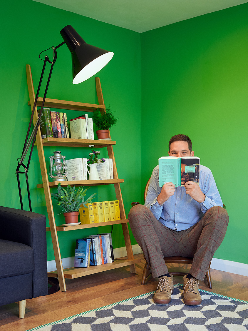 William Mandy reading a book in his home office.