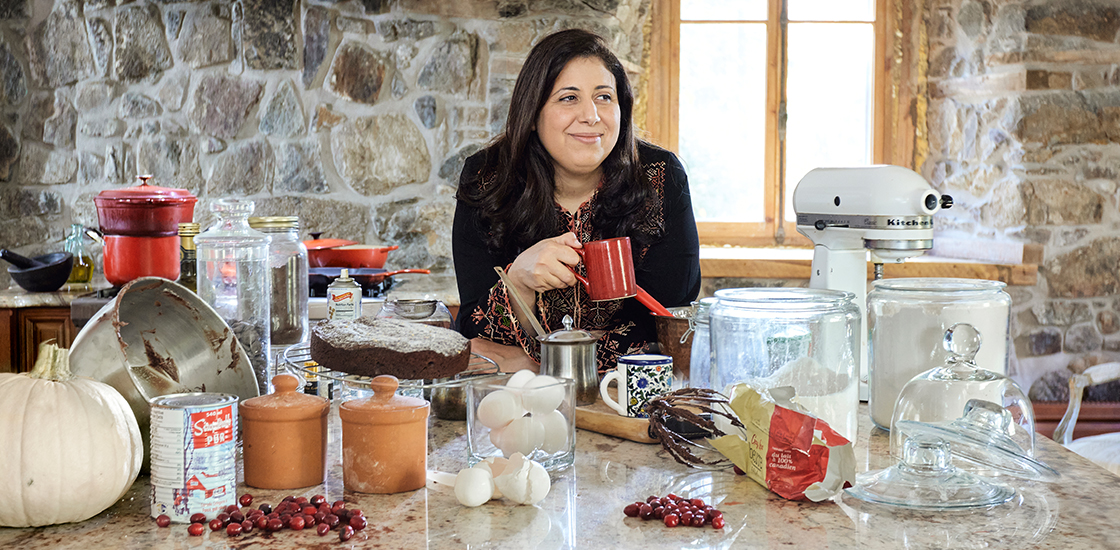 Mayada Elsabbagh portrait in her messy kitchen, drinking coffee.