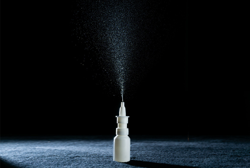 Photo: A nasal spray bottle sprays upwards.