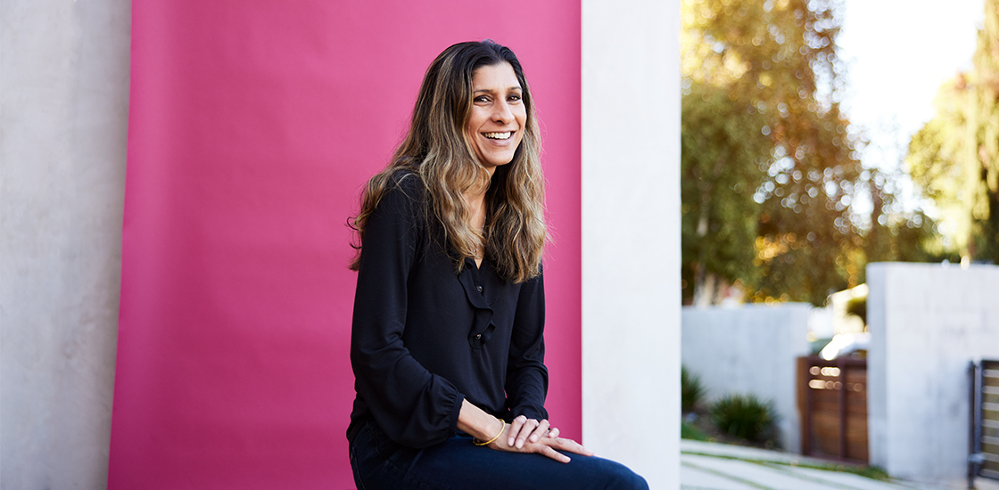 Dr. Shafali Jeste portrait with a vibrant fuschia background.