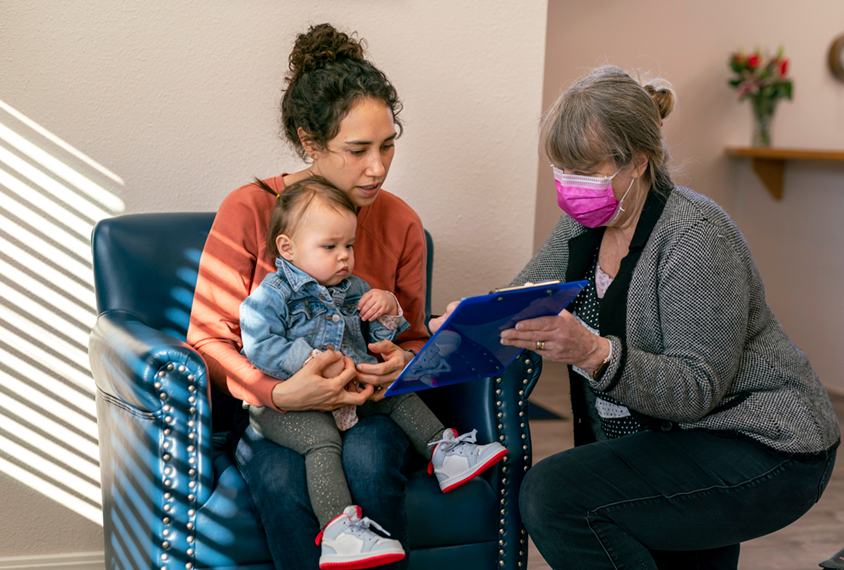 Parent with toddler and clinician with clipboard.