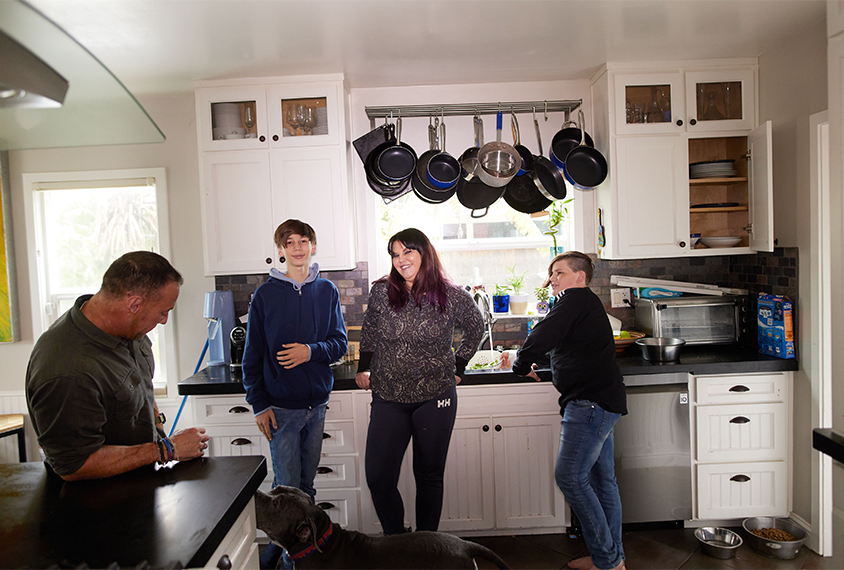 Jill Silverman stands in her kitchen with her family.