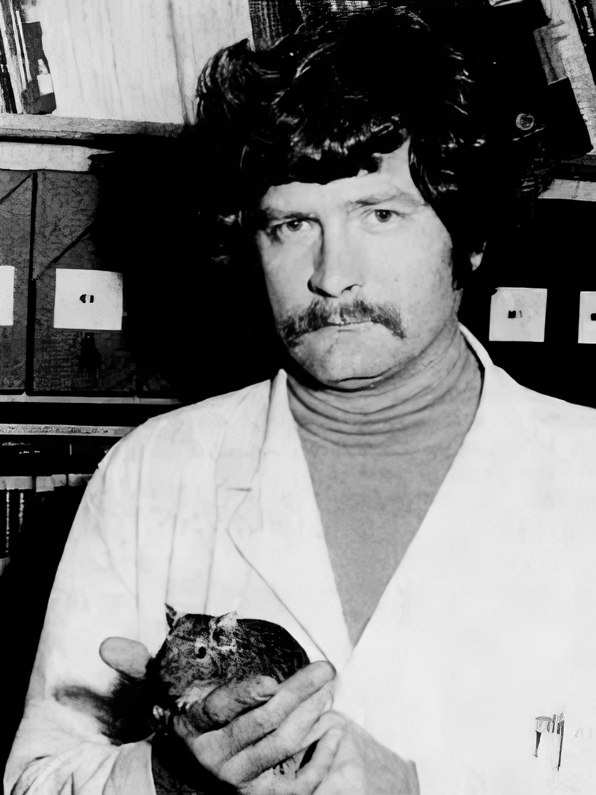 Black-and-white photograph of David Boraker holding a degu.