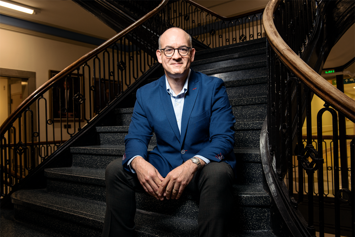 Portrait of Matthew Siegel sitting on a staircase.