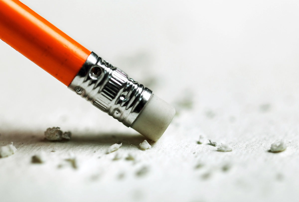 Illustration of a red pencil with a white eraser that is being used against a white sheet of paper.