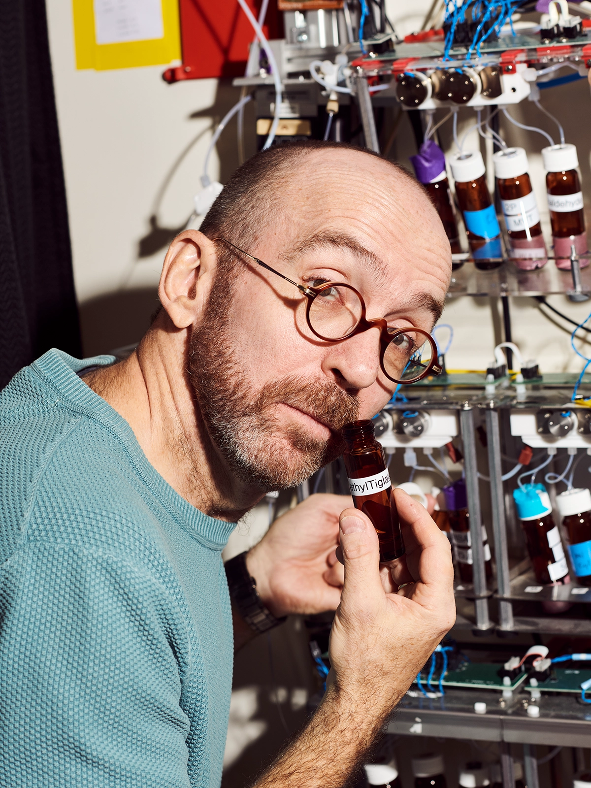 Dima Rinberg smells one of the compounds in his lab, looking at camera with a quizzical expression.