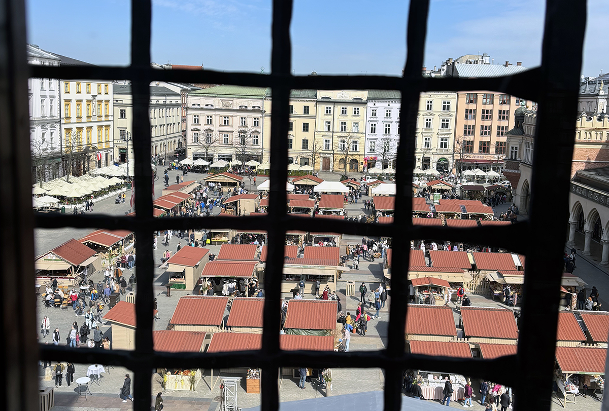 View out a window onto an open plaza in Krakow.