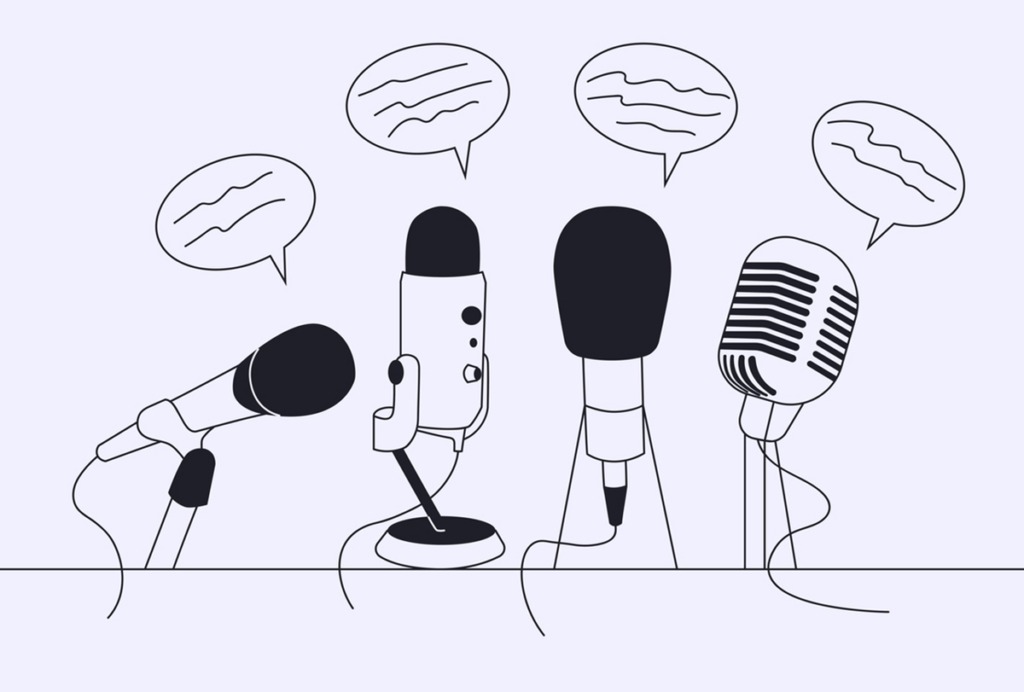 Four microphones on a table with speech bubbles above them.