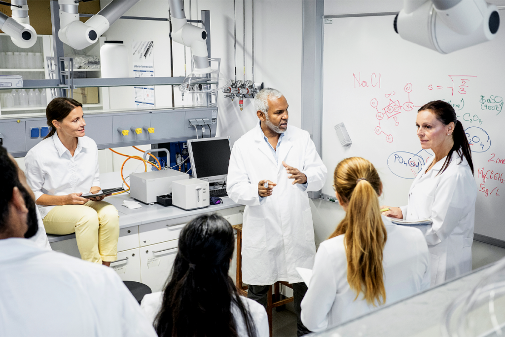 A group of scientists discusses in a lab.